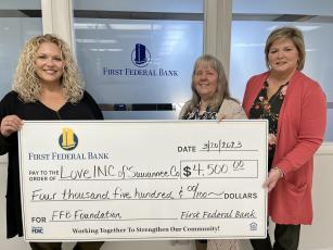 First Federal Bank Financial Manager Heather Thompson (left) and Regional Manager Pam Cochran (right) present Love INC Executive Director Martha Wood a $4,500 grant that will help the Suwannee County non-profit meet its monthly obligations in the community. (COURTESY)