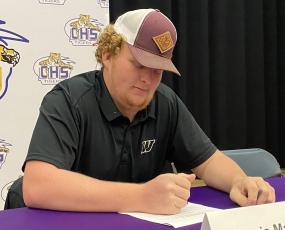 Columbia offensive lineman Travis Matthews signs his letter of intent to play with Webber International on Friday. (COURTESY)