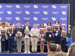 Fort White Middle School’s Cyler Robinson (center) receives his first-place recognition at the State Science and Engineering Fair of Florida in Lakeland on April 4-6. (COURTESY)
