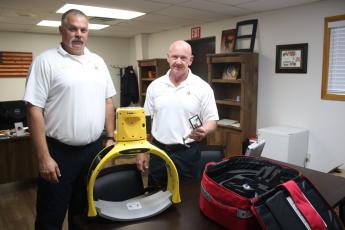 Columbia County Assistant Fire Chief Lance Hill (from left) and Fire Chief Jeff Crawford show off two new pieces of medical equipment, a Defib Tech Lifeline Arm unit, which is an automated compression devices for CPR and a video laryngoscope. CCFR also has a new brush truck that was put into service Friday. (TONY BRITT/Lake City Reporter)