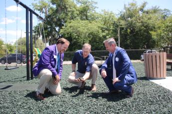 District Rotary Governor Dan Sulger (left), Rotary Club of Lake City President Jay Swisher (right) and Lake City Rotarian John Wheeler take a closer look at the rubber mulch that replaced sand at the Rotary Children’s Playground at downtown Wilson Park. (TONY BRITT/Lake City Reporter)