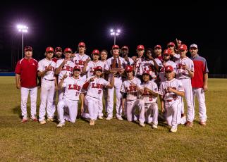 Lafayette celebrates with the District 6-1A championship trophy after defeating Union County 9-8 on Thursday night. (JACK HOWDESHELL/Special to the Reporter)