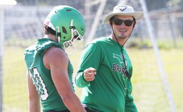 Suwannee offensive coordinator Joseph Gaddy speaks with quarterback Kodi Lang during practice on May 1. (JAMIE WACHTER/Special to the Reporter)