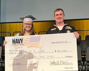 GM1 (SW) William McCracken presents Suwannee Virtual School graduate Gladette Lane with a symbolic signing bonus check for $48,000 from the United States Navy on Friday. (COURTESY)