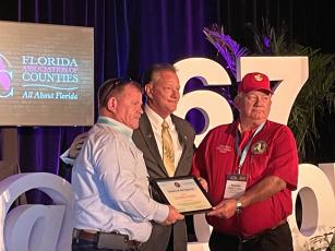 Columbia County Commissioners Tim Murphy (left) and Everett Phillips (right) accept the County of the Quarter award from the Florida Association of Counties. (COURTESY)