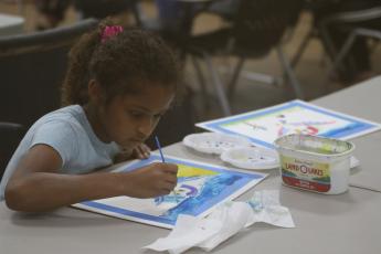 Aaliyah Singh concentrates on her watercolor painting Friday during the Young Da Vinci Art Camp at the Gateway Art Gallery. (JAMIE WACHTER/Lake City Reporter)