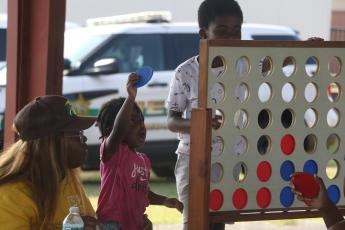 Tylie Davis looks to make a play during a ‘Connect 4’ game with Tyrice Baynard as Katie McGowan looks on Friday during the Summer Nights program at Melrose Park Elementary School. (MORGAN MCMULLEN/Lake City Reporter)