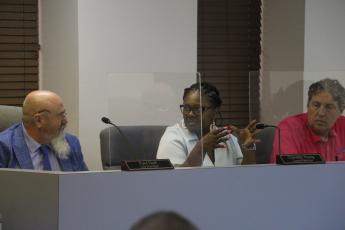 Councilwoman Chevella Young (middle) speaks to City Manager Paul Dyal as Councilman Todd Sampson listens during Monday’s Lake City Council meeting. (MORGAN MCMULLEN/Lake City Reporter)