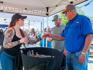 An Ancient City Brewing employee serves up a drink to a festivalgoer at last year’s Gateway City Craft Beer & Wine Festival in downtown Wilson Park. (COURTESY)