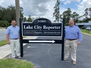 Lake City Reporter Editor Jamie Wachter (left) and Publisher Todd Wilson stand beside the newspaper’s relocated sign street side at 1086 SW Main Blvd., where the newspaper has relocated to Suite 103 of the former Social Security office complex. The Reporter completed its move earlier this month after selling its 11,000 square foot building on Duval Street downtown to Columbia County earlier this year. The signs were moved earlier this week. (JULIA GASPARRINI/Lake City Reporter)
