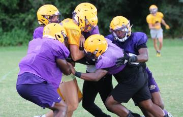 Columbia’s defense swarms to tackle receiver Camdon Frier during Friday’s practice. (JORDAN KROEGER/Lake City Reporter)