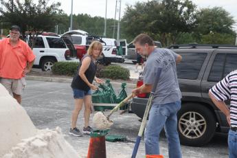 Elizabeth and Darryl Boyette prepare and load sandbags at the Southside Sports Complex Tuesday morning ahead of Hurricane Idalia’s expected landfall Wednesday morning. (MORGAN MCMULLEN/Lake City Reporter)