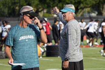 Jacksonville Jaguars head coach Doug Pederson (right) talks with quarterbacks coach Mike McCoy (left) during a practice on Aug. 1 in Jacksonville. (JOHN RAOUX/Associated Press)