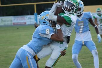 Suwannee wide receiver Daijuan Perkins catches a pass Friday night as a Chiefland defensive back delivers a hit at Pridgeon Stadium. (JAMIE WACHTER/Lake City Reporter)