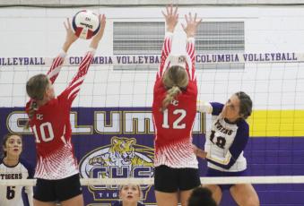 Columbia outside hitter Autumn Jones sends a shot past Dixie County’s Hailey Moody (10) and Kailey Edmonds (12) on Wednesday night. (JORDAN KROEGER/Lake City Reporter)