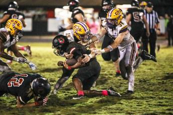 Columbia linebacker Tyson Yaxley (15) and defensive lineman Kyten Davis (34) make a tackle against Middleburg on Friday. (BRENT KUYKENDALL/Lake City Reporter)