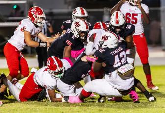 Fort White defenders converge for a tackle against Dixie County on Oct. 13. (JACK HOWDESHELL/Special to the Reporter)