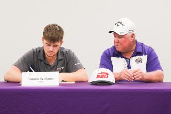 Columbia golfer Connor Williams (left) signs his letter of intent to play at Southeastern University on Friday alongside CHS head coach Sherman Reed. (COURTESY)