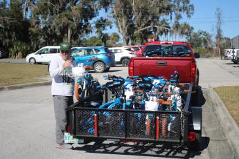 Mike Kelley, Suwannee Bicycle Association vice president, unloads a child’s bike from a trailer on Wednesday afternoon. (TONY BRITT/Lake City Reporter)