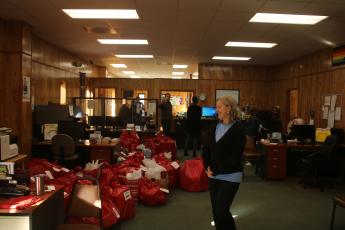 Joanie LeRoy, a Christian Service Center volunteer, looks over bags of toys and other gifts that were prepared for distribution to local families on Monday. (TONY BRITT/Lake City Reporter)