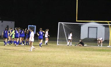 Columbia goalkeeper Penelope Wheeldon sits in goal as the Blue Devils celebrate the game-ending score in the second half of Friday’s District 2-5A semifinal. (MORGAN MCMULLEN/Lake City Reporter)