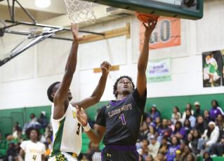 Columbia guard Marlin Haywood makes a layup while being defended by Suwannee guard MJ Rossin on Tuesday night. (PAUL BUCHANAN/Special to the Reporter)