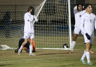 Columbia defenders Bobby Shotwell (14), Eduardo Morales (6) and Jonathan Pineda (1) react to a Clay goal as goalkeeper Augustus Mock sits on his knees in the goal during Monday's District 2-5A semifinal. (JORDAN KROEGER/Lake City Reporter)