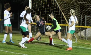 Suwannee goalie Layla Merola stops a shot just as Santa Fe’s Amelia Whitehurst crashes into the box in the second half of Wednesday’s District 2-4A championship. (MORGAN MCMULLEN/Lake City Reporter)