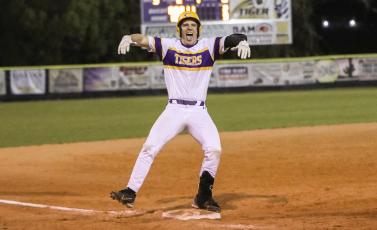 Columbia third baseman Ayden Phillips celebrates on third base after hitting a triple to cap off his cycle against Santa Fe on Tuesday night. (BRENT KUYKENDALL/Lake City Reporter)