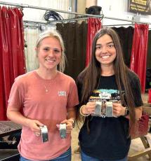 CHS welders Karsyn Sims (left) and Madison Bailey became the first female students at CHS to earn their welding certificates after passing their tests Tuesday. (COURTESY)