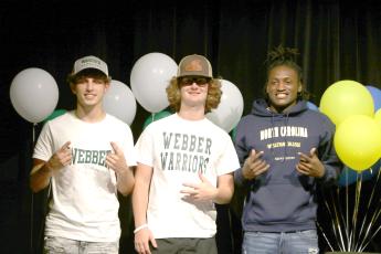 Fort White soccer players Gavin Heaton (left) and Connor Bass (right) signed their letters of intent with Webber International, while football player Maliki Clark (right) signed with North Carolina Wesleyan on Thursday. (MORGAN MCMULLEN/Lake City Reporter) 
