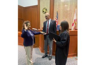 Tina Siefert (left) is sworn in as the Third Judicial Circuit’s new General Magistrate by Chief Judge Melissa Olin as Seifert’s fiancee John Blanchard holds the Bible during the private swearing-in ceremony Friday in the Columbia County Courthouse. (COURTESY)
