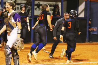Branford coach Oscar Saavedra celebrates with Cloey Criggall after she scored the game-winning run against Bell on Friday. (MORGAN MCMULLEN/Lake City Reporter)