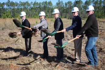 AgroLiquid adminstrators David Gilliam (from left), Gerrit Bancroft, Nick Bancroft, Alan Kennedy and Todd Cressman toss dirt from their shovels during a March groundbreaking ceremony for the company’s new plant at the North Florida Mega Industrial Park. (FILE)