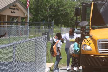 Makeba Murphy, Niblack Elementary School principal, hugs students on the final day of school before they board their buses. The Niblack school building is scheduled to be demolished in a few weeks and a new school building erected on the site. (TONY BRITT/Lake City Reporter)
