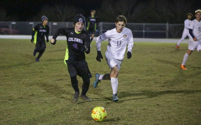 Columbia’s TJ Hudson races with Santa Fe’s Colton Weiser for possession of the ball on Thursday night. (BRENT KUYKENDALL/Lake City Reporter)