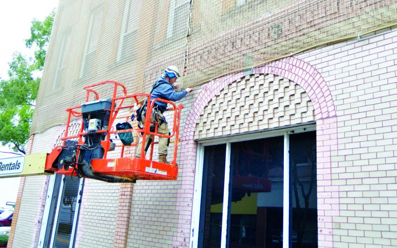 A worker installs netting around City Hall on North Marion Avenue to keep bricks from falling onto pedestrians in this November 2018 file photo. (FILE)