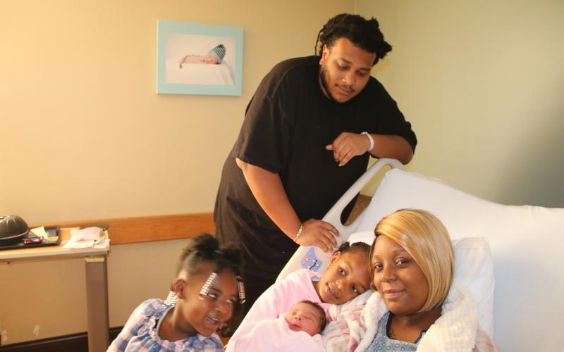 Sariyah Jones (from  left), Aniyah Jones, Alexander Jones and Kadijah Williams pose with Alexis Zakiyah Jones Thursday afternoon. Alexis Zakiyah, who came into the world Wednesday night, was the first baby born in Lake City in 2020. (TONY BRITT/Lake City Reporter)