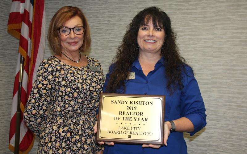 Susan Eagle (left), the 2020 Lake City Board of Realtors President, stands with Sandy Kishton after she presented Kishton with the 2019 Realtor of the Year Award during Monday’s Lake City Board of Realtors 2020 Installation Luncheon at the Lake City Holiday Inn. (TONY BRITT/Lake City Reporter)