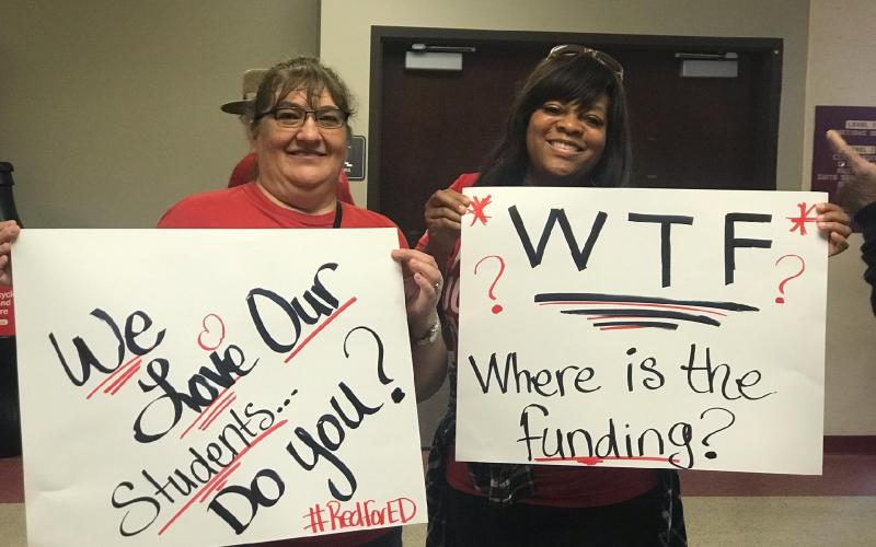 Tammy Garrett (left), a Lake City Middle School teacher, and Tanya Johnson, Columbia Teachers Association president, hold signs at  the Tallahassee Civic Center Monday, before marching the rally Monday. (COURTESY)