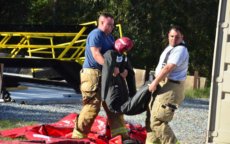 Firefighters lug a search-and-rescue dummy. Friday’s drills marked the end of a week-long gauntlet of training exercises, the first time CCFR has hosted personnel from agencies outside the county. (CARL MCKINNEY/Lake City Reporter)