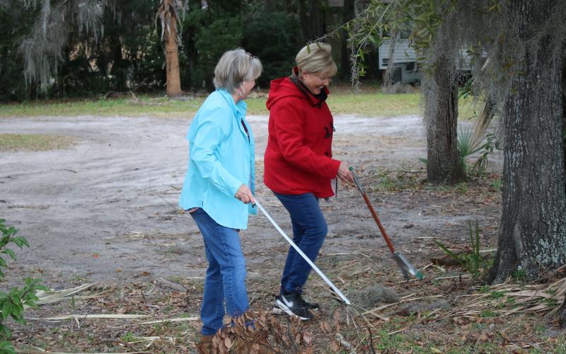 Garden Club members Carol Stevens and Tina Roberts pick up litter near McCray Avenue on Saturday during Lake City’s inaugural “Take Pride in Your Community Clean-Up Campaign.” (MICHAEL PHILIPS/Lake City Reporter)