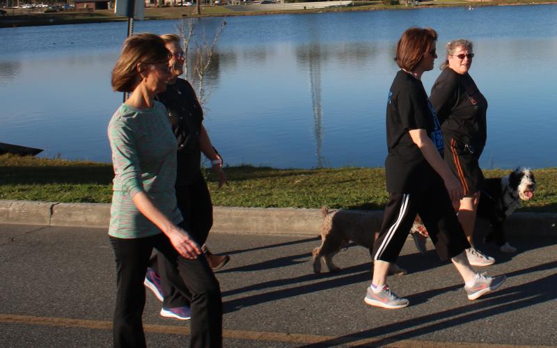 School district employees walk around Lake DeSoto on Monday afternoon as part of the new wellness initiative. The group walked three miles their first time out. (TONY BRITT/Lake City Reporter)