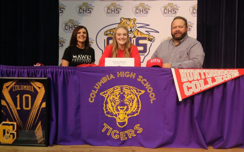 Columbia volleyball player Lauren Wilson (middle) signed her national letter of intent Monday to play at Huntingdon College in Montgomery, Ala. alongside her mother Michelle Wilson and her father Todd Wilson. (JORDAN KROEGER/Lake City Reporter)
