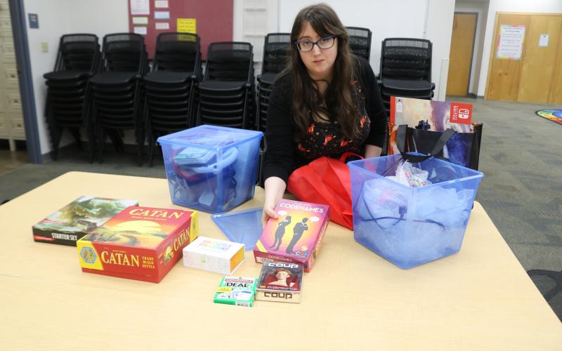 Emma Miles, Columbia County Library programs specialist, unpacks board and table-top games that will be featured in the library’s inaugural Teen Gaming League Night, set for 4-5 p.m. Wednesday. (TONY BRITT/Lake City Reporter)