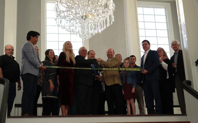 City officials and representatives of IDP Properties cut the ribbon during a ceremony Thursday afternoon at the Blanche’s main staircase.  (TONY BRITT/Lake City Reporter)