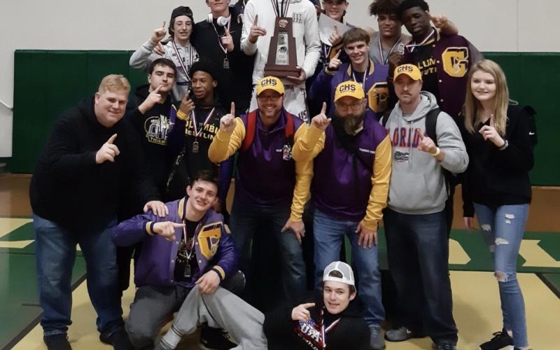 Columbia's wrestling team celebrates is pictured with the trophy after winning the District 2-2A IBT Tournament on Saturday. (COURTESY)