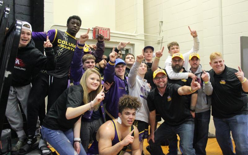 Columbia’s wrestling team celebrates winning the District 2-2A IBT championship on Saturday. (COURTESY)
