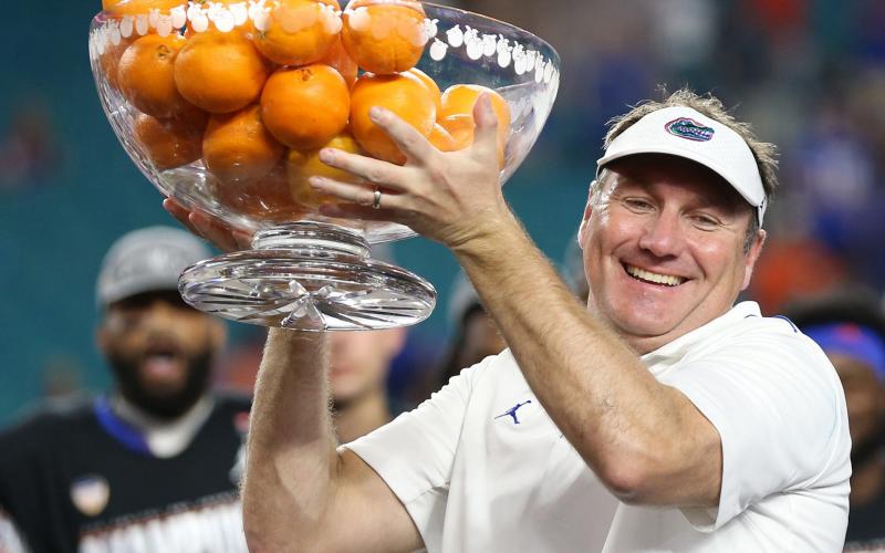 Florida head coach Dan Mullen raises the championship bowl of oranges after the Gators defeated Virginia in the Capital One Orange Bowl at Hard Rock Stadium on Dec. 30, 2019, in Miami Gardens. (AL DIAZ/Miami Herald/TNS)