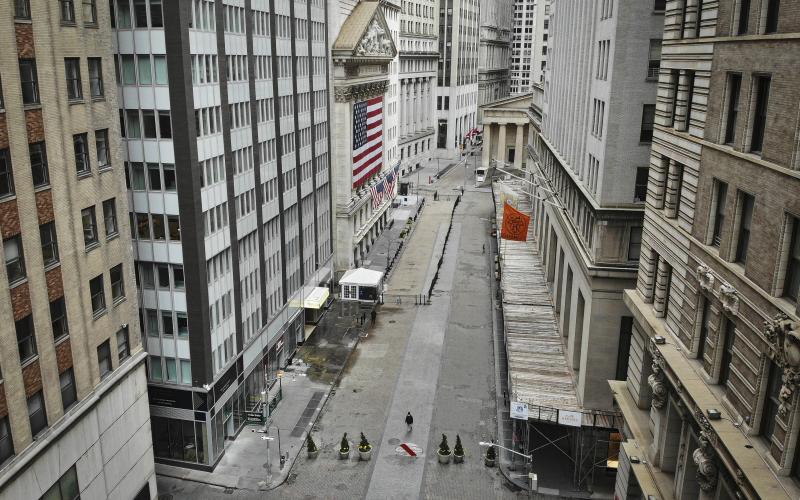 A lone pedestrian wearing a protective mask walks past the New York Stock Exchange as coronavirus concerns empty a typically bustling downtown area in New York on Saturday. (AP FILE PHOTO)